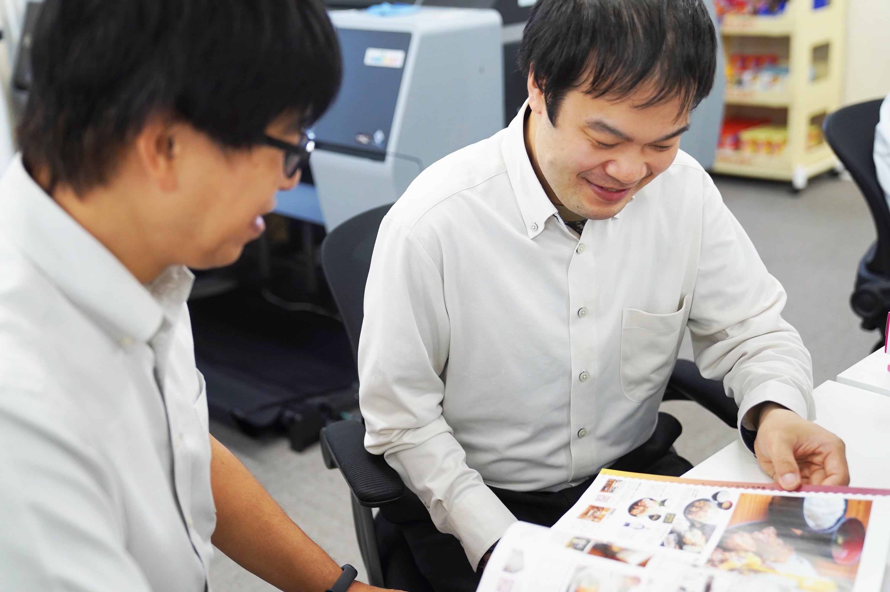 印刷された冊子を確認する高田さん(左)と渡部さん(右)。
